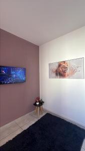 a room with three pictures on the wall and a table at Doce Lar 3 in Pouso Alegre
