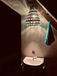 a bathroom with a sink and a light fixture at MudHouse Retreat, Sarajara in Bīr +85 photos