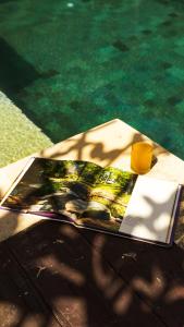 a magazine sitting on a table next to a pool at Joglo Villa with Private Pool in Pesanggaran
