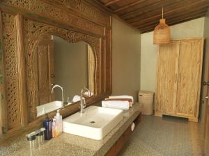 a bathroom with a sink and a large mirror at Joglo Villa with Private Pool in Pesanggaran +17 photos