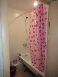 キーロフにあるApartments Azina 17のバスルーム(ピンクのシャワーカーテン、バスタブ付)