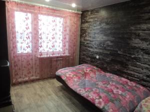 キーロフにあるApartments Azina 17のレンガの壁、ベッド付きのベッドルーム1室
