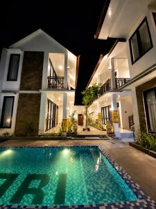 a swimming pool in front of a house at night at Pondok Biu 2 in Denpasar +10 photos