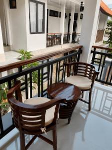 a balcony with two chairs and a bar at Pondok Biu 2 in Denpasar