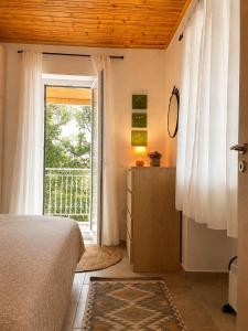 a bedroom with a bed and a door to a balcony at Taygetos hut in Dhirrákhion