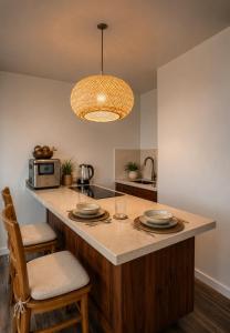 a kitchen with a counter with plates and a microwave at Wake Up to the Ocean - Beachfront Studio in Hauula