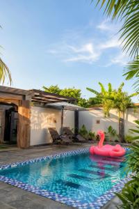 an inflatable flamingo in a swimming pool next to a house at Pondok Biu 2 in Denpasar