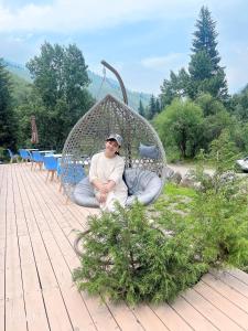 a man sitting in a swing on a deck at Dream house in Türgen +16 photos