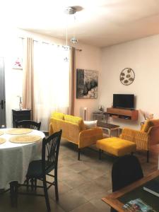 a living room with a table and yellow furniture at L'Empire D'Essences Appartement in Valréas