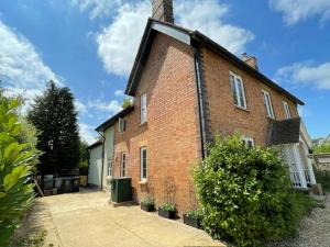 a large brick building with a chimney on it at Elm Cottage in Alvescot