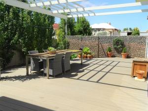 a patio with a table and chairs under a pergola at Ripplesea in Port Moonta