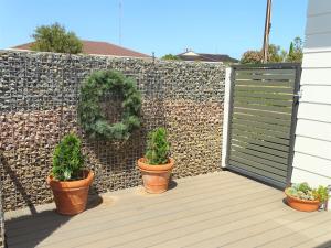 a fence with three potted plants on a wooden deck at Ripplesea in Port Moonta +4 photos