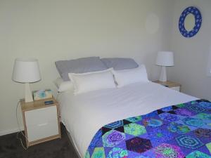 a bedroom with a bed with a quilt on it at Ripplesea in Port Moonta