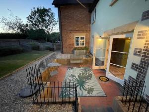 a patio in front of a house with a fence at Elm Cottage in Alvescot +39 photos