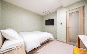 a bedroom with a white bed and a television at the stay in Seoul +103 photos