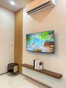 a living room with a flat screen tv on the wall at Rose & Nainee House Hatyai in Ban Tha Thon