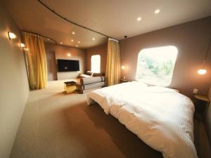 a bedroom with a large white bed and a window at Over the MOON in Awaji