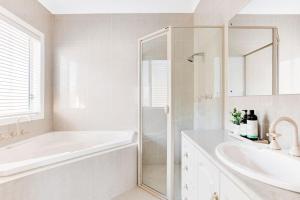 a white bathroom with a tub and a sink at The Stately Way in Wallaroo +2 photos
