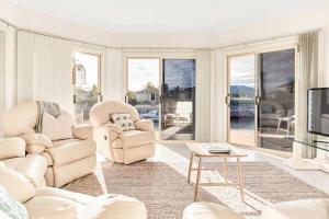 a living room with two chairs and a tv at The Stately Way in Wallaroo