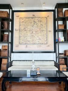 a table with a map on a wall with shelves at 99 The Gallery Hotel in Chiang Mai