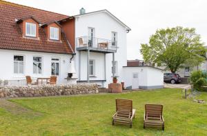 two chairs sitting in the grass in front of a house at Ille in Wittdün