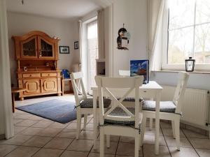 a dining room with a white table and chairs at Hygge in Nebel