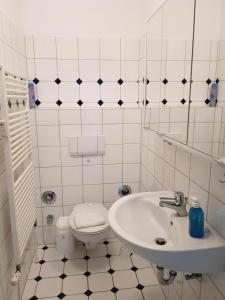 a white bathroom with a toilet and a sink at Hygge in Nebel +6 photos