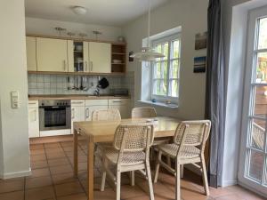 a kitchen with a wooden table and chairs at Dethlefs in Nebel