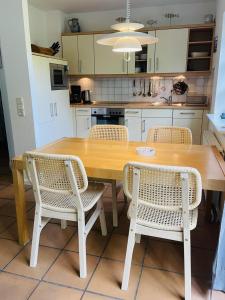 a kitchen with a wooden table and chairs at Dethlefs in Nebel +12 photos