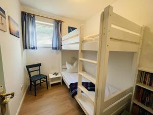 a bedroom with two bunk beds and a chair at Dethlefs in Nebel