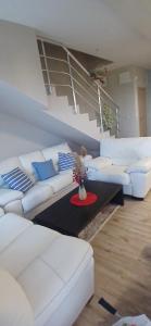 a living room with a white couch and a table at Къща Уют in Rogachevo