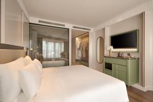 a bedroom with a large white bed and a television at Solaria d'Oriente Hotel in Hanoi