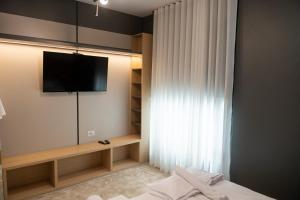 a bedroom with a tv on a wall with a curtain at Chalet Port Bicaz in Bicaz