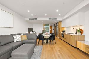 a living room and kitchen with a couch and a table at Kove Apartment - G03 in Kiama