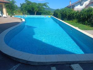 a large swimming pool with blue water at Къща Уют in Rogachevo