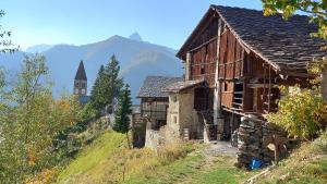 an old building on the side of a hill with a church at Bed & Breakfast Barba Bertu di Frassino in Frassino +88 photos