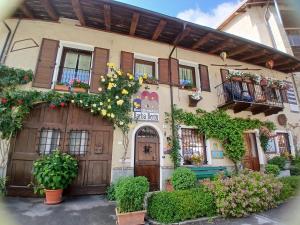 a building with flowers and plants in front of it at Bed & Breakfast Barba Bertu di Frassino in Frassino
