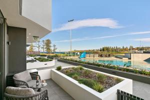 a balcony with chairs and a view of the water at Kove Apartment - G05 in Kiama