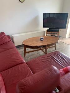 a living room with a couch and a table with a tv at HaK-3 in Wittdün +3 photos