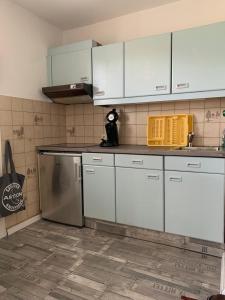 a kitchen with white cabinets and a dishwasher at HaK-3 in Wittdün