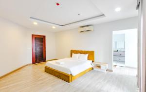a white bedroom with a bed and a window at Tiffany Resident Apartment in Siem Reap