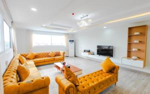 a living room with two couches and a tv at Tiffany Resident Apartment in Siem Reap
