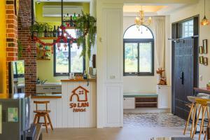 a kitchen with yellow walls and a door with a house sign at 50 Lan House in Yilan City