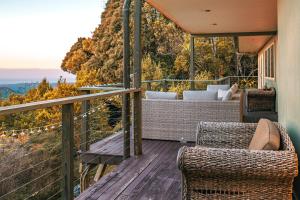 a balcony with wicker chairs and a view of the mountains at Serenity Rainforest Retreat With Breathtaking Gold Coast Views - Sleeps 4 - 6 people in Springbrook