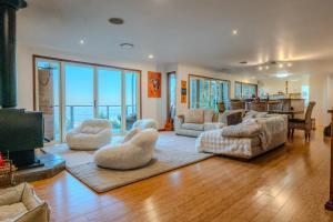 a living room with a couch and chairs and a television at Serenity Rainforest Retreat With Breathtaking Gold Coast Views - Sleeps 4 - 6 people in Springbrook