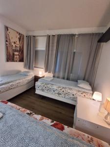 a bedroom with two beds and two windows at KEF QuickStay Apartments in Keflavík