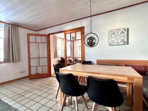 a dining room with a wooden table and black chairs at Tiramisu in Wittdün
