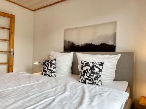 a bedroom with a white bed with two pillows at Tiramisu in Wittdün