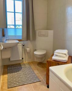 a white bathroom with a sink and a toilet at Tiramisu in Wittdün +12 photos