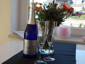a bottle of wine and two glasses on a table at kleiner-Fiete in Wittdün